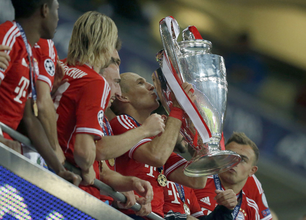 Bayern Munich's Arjen Robben holds the trophy with team mates after defeating Borussia Dortmund in their Champions League Final soccer match at Wembley Stadium in London